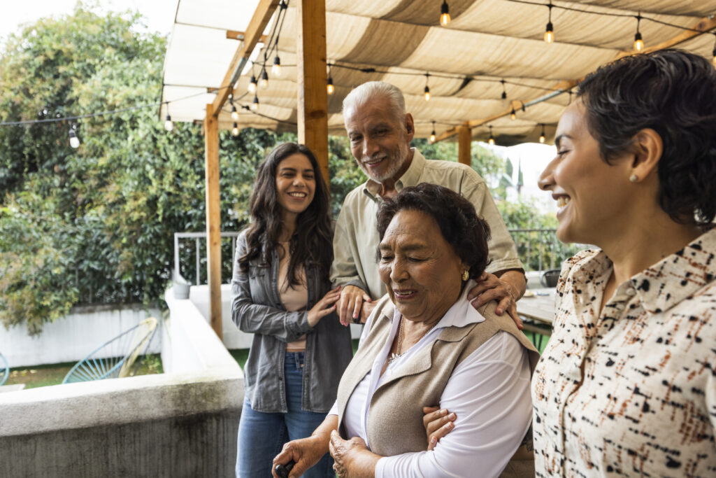 Two women walking arm in arm with senior man and woman