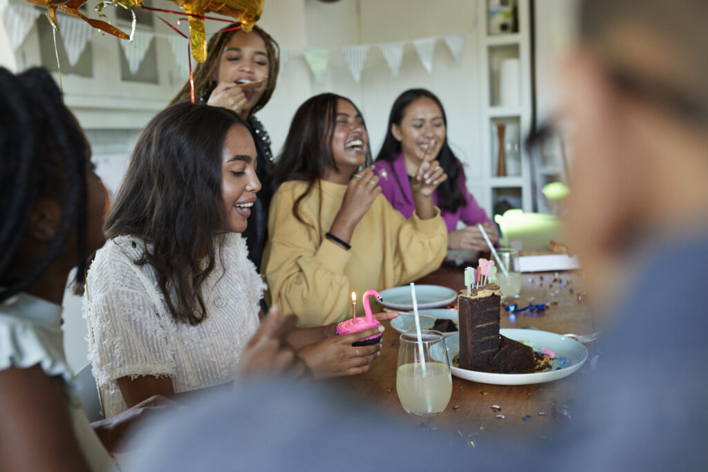 Smiling woman with friends looking at cupcake