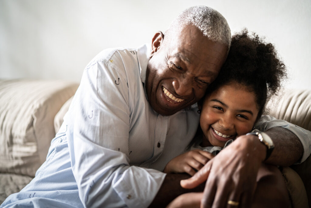 Portrait of grandfather embracing granddaughter